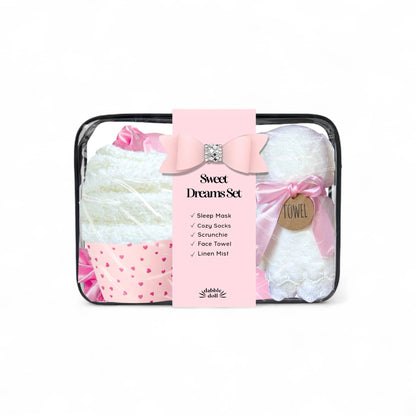 Dabble Doll sleep gift set in pink featuring a sleep mask, cozy socks, scrunchie, and linen mist for women