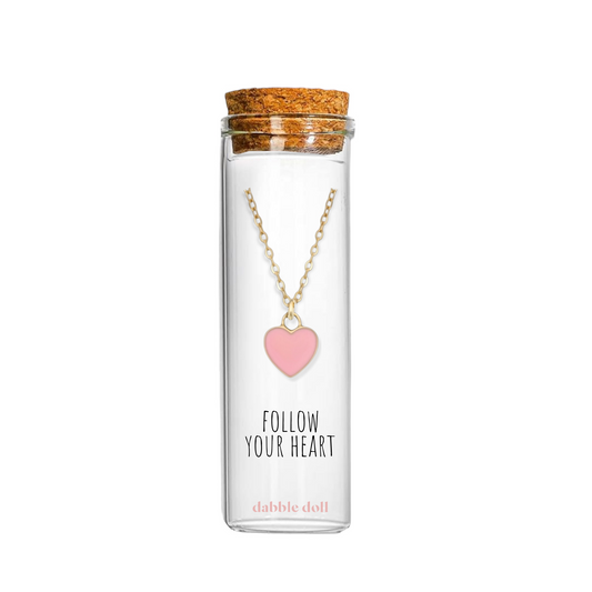 Dabble Doll Tiffanys necklace heart in pink, displayed in a glass bottle with a cork lid.