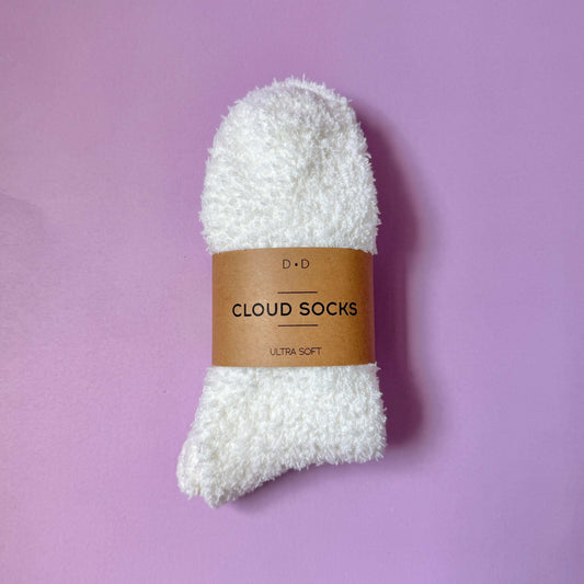 Dabble Doll ultra soft cloud socks in white packaging on a purple background