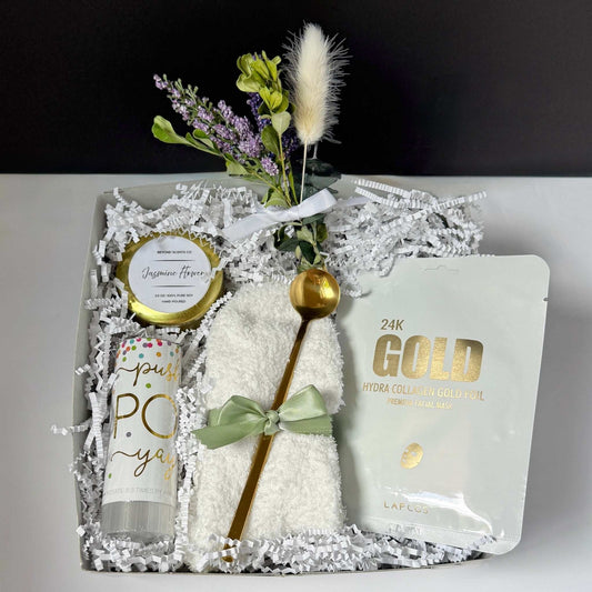 Dabble Doll unique celebration gift basket with gold spoon, facial mask, jasmine flower candle, and towel in decorative box